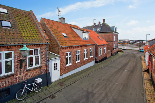 Byhus n�r havn og strand i R�nne